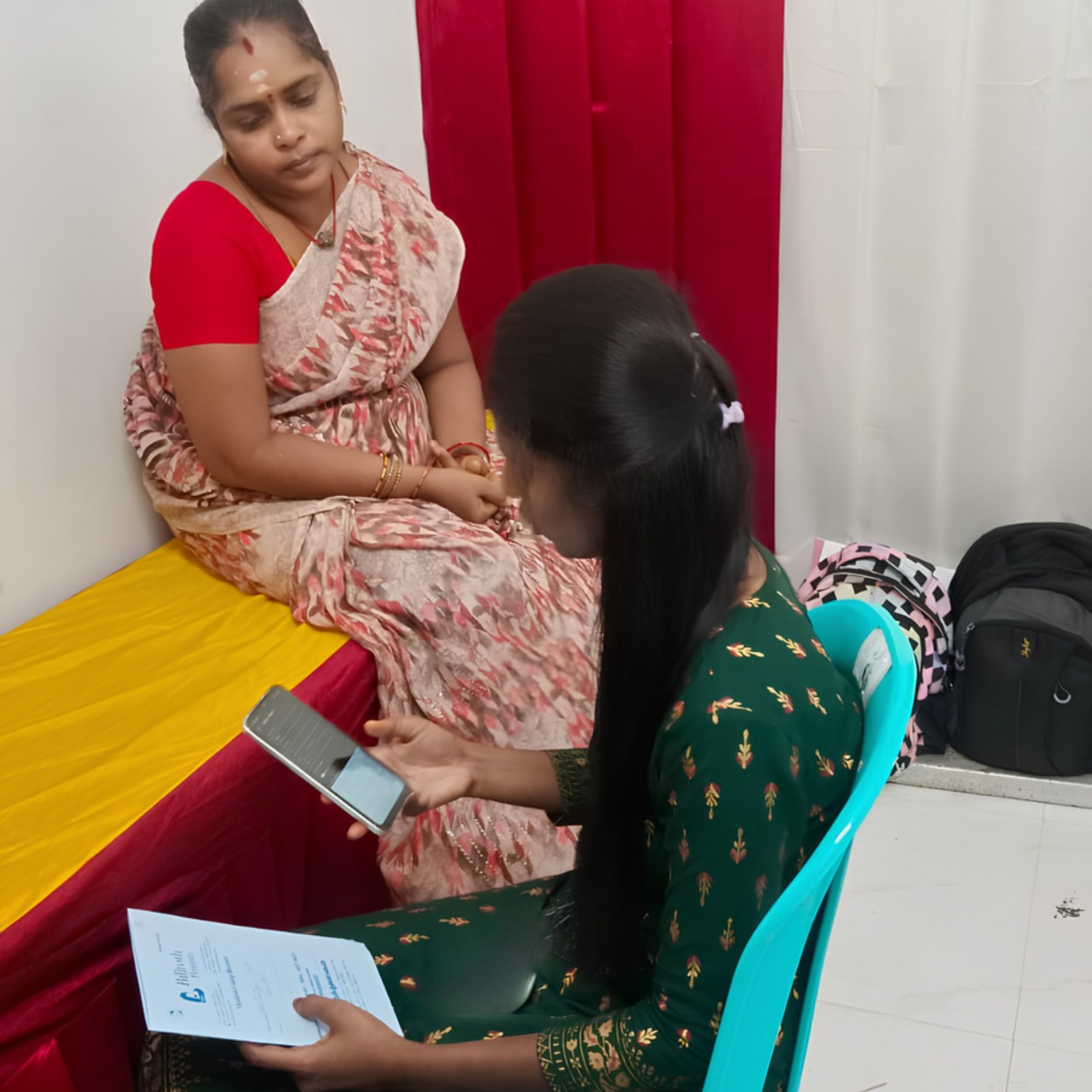 A volunteer explaining breast health information one to one with a woman