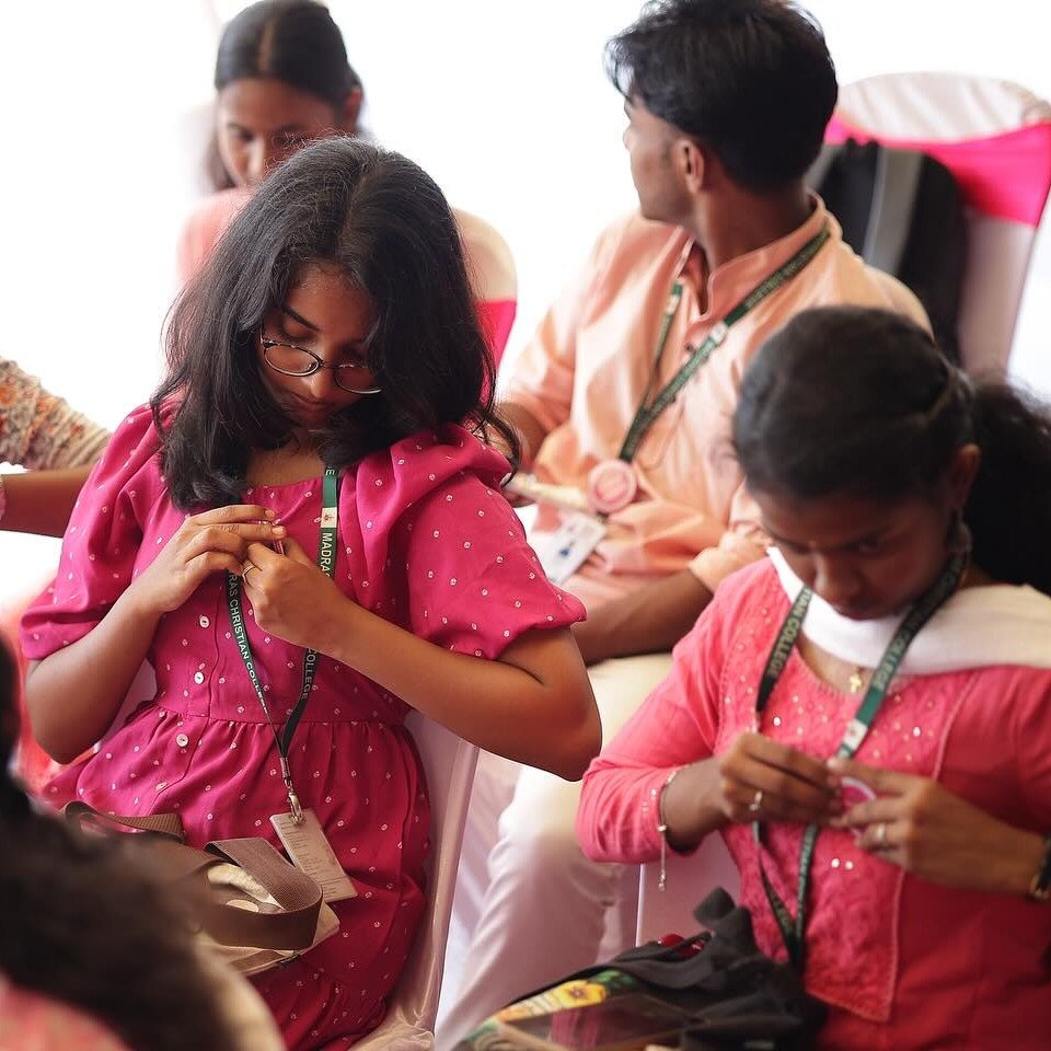 Students pinning pink ribbons on one another at an India Turns Pink awareness session